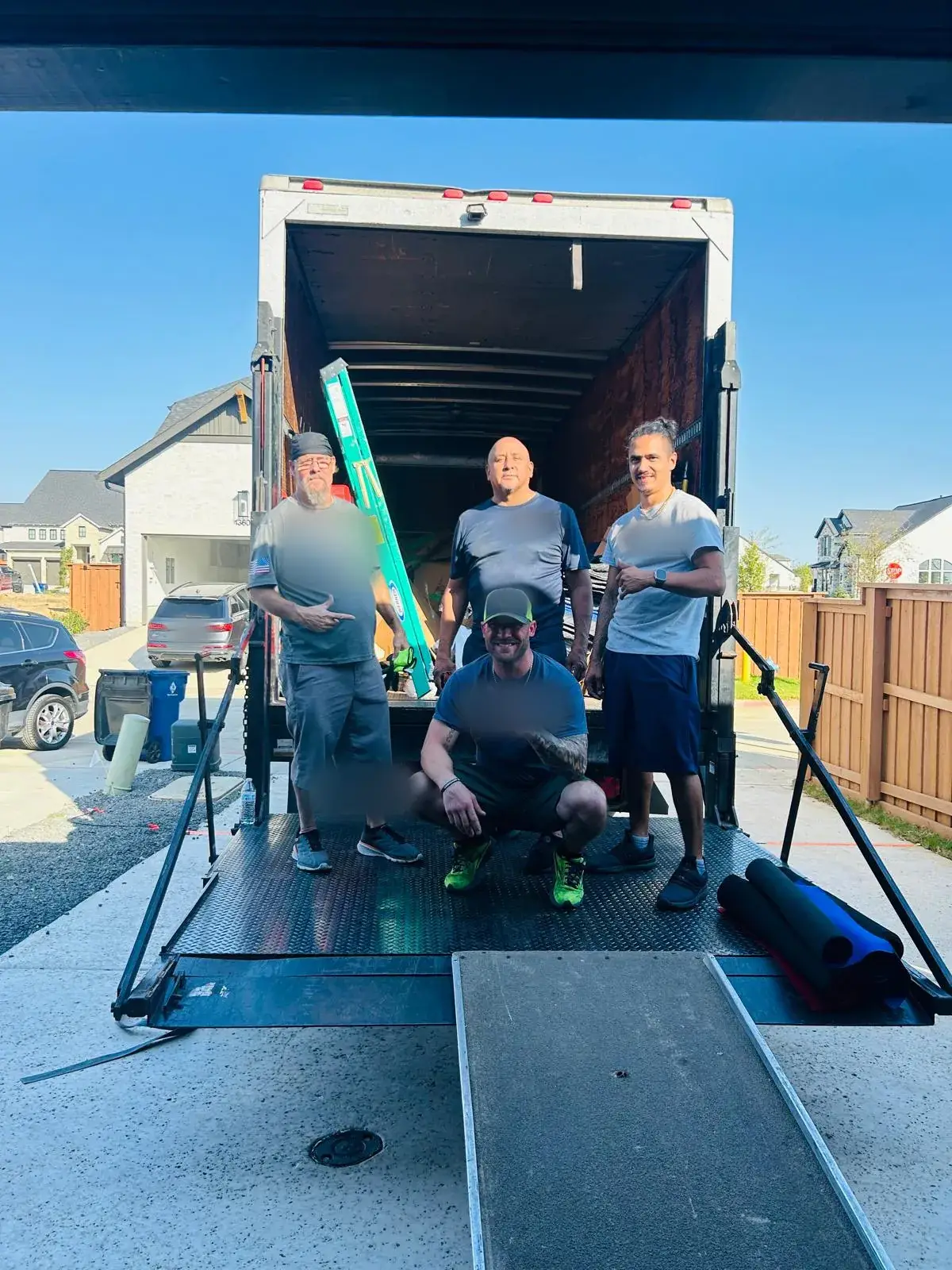 Champion Moving crew of four on the liftgate of a moving truck