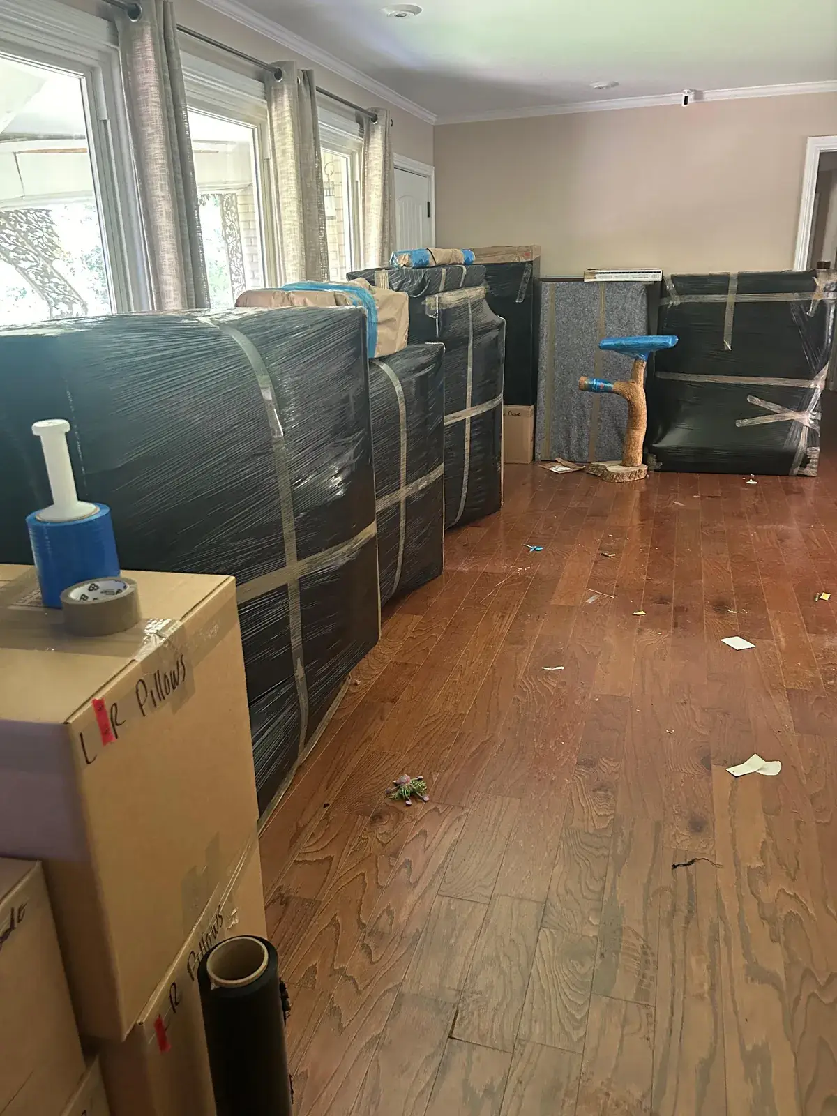 Living room lined with padded, stretch-wrapped furniture ready for the truck