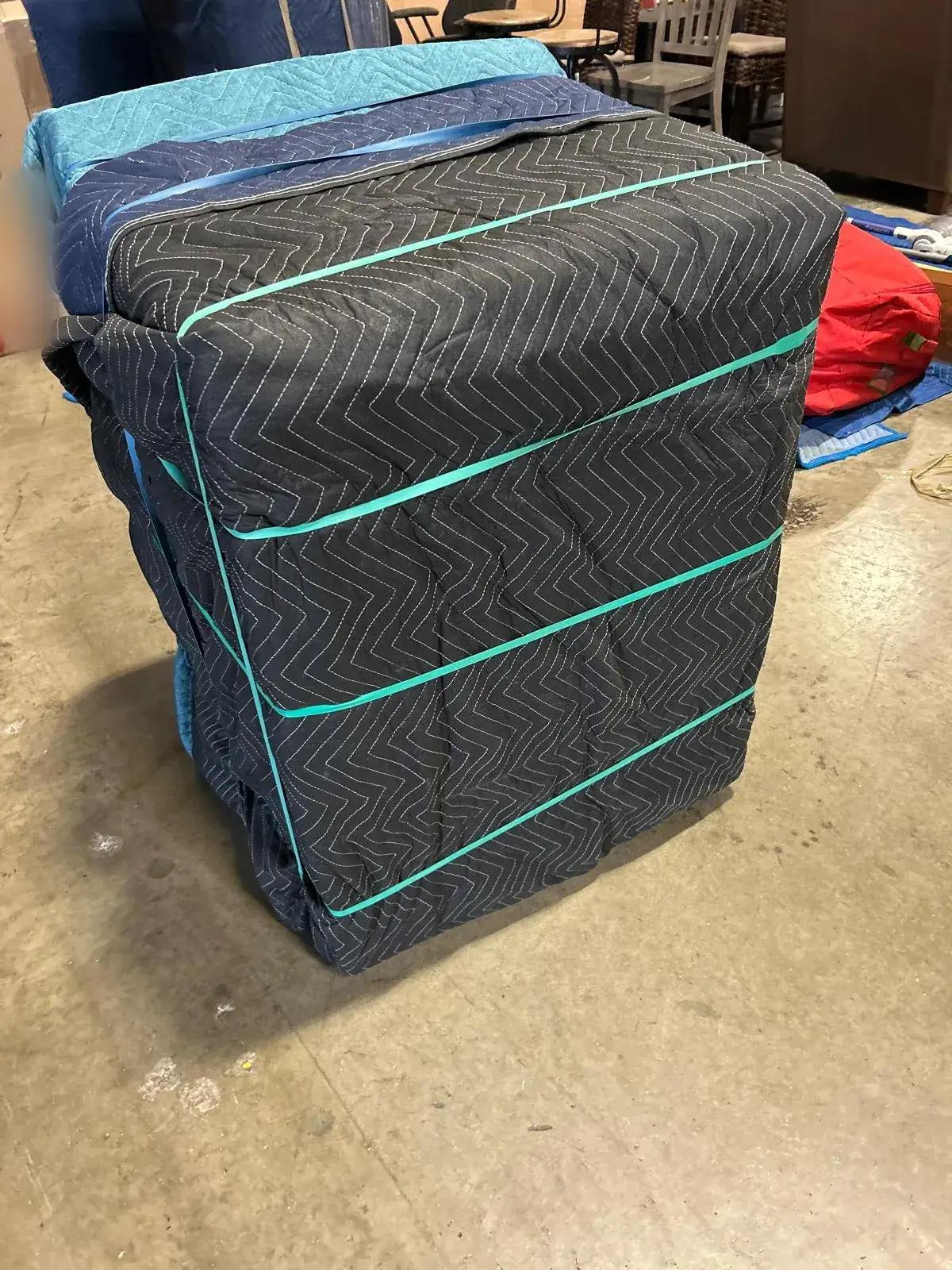 Furniture wrapped in moving blankets and secured with straps