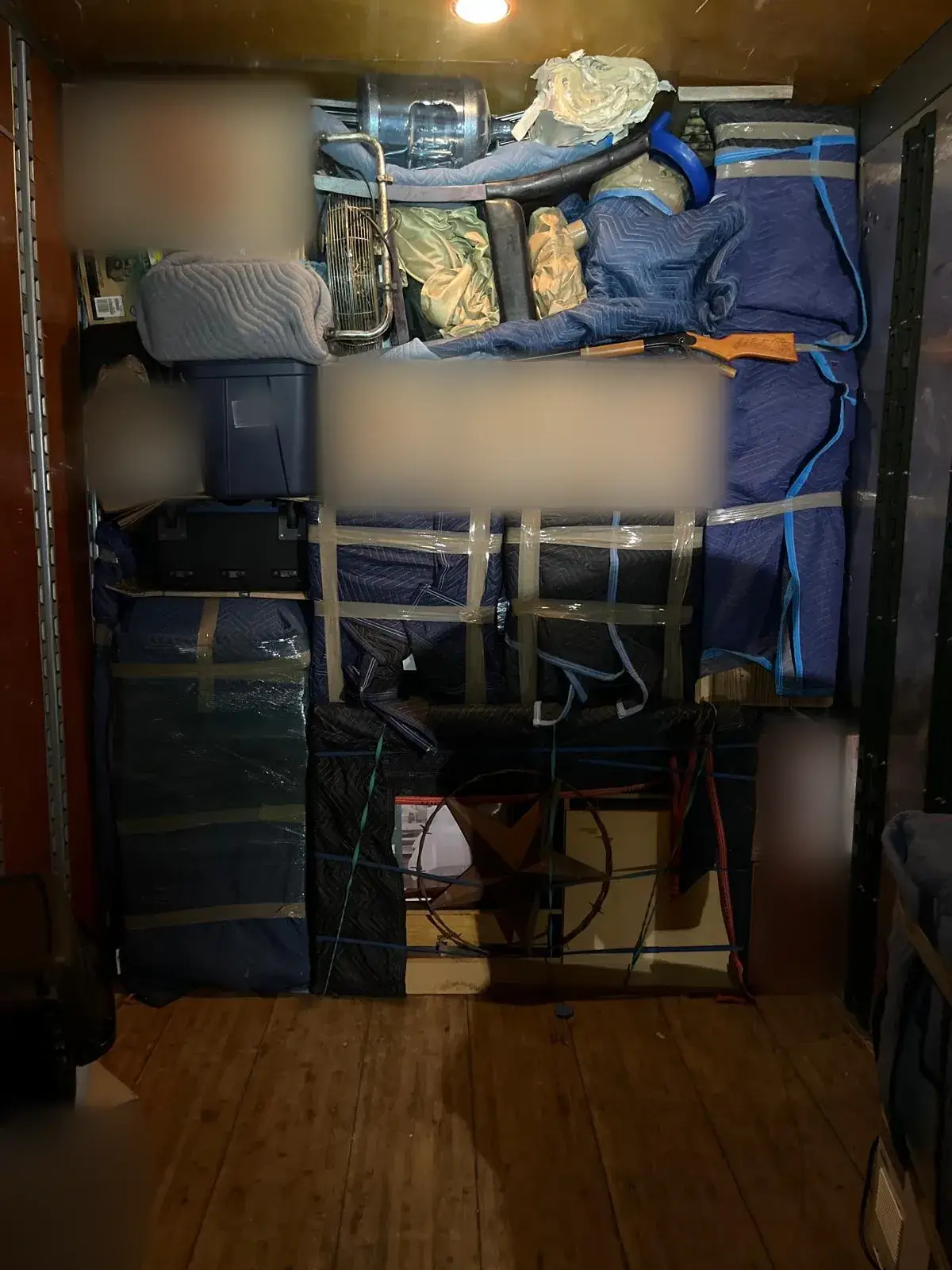 Moving truck interior tightly packed with blanket-wrapped furniture and boxes