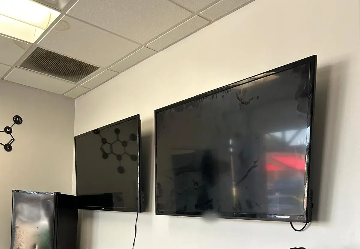 Two flat-screen TVs mounted on an office wall
